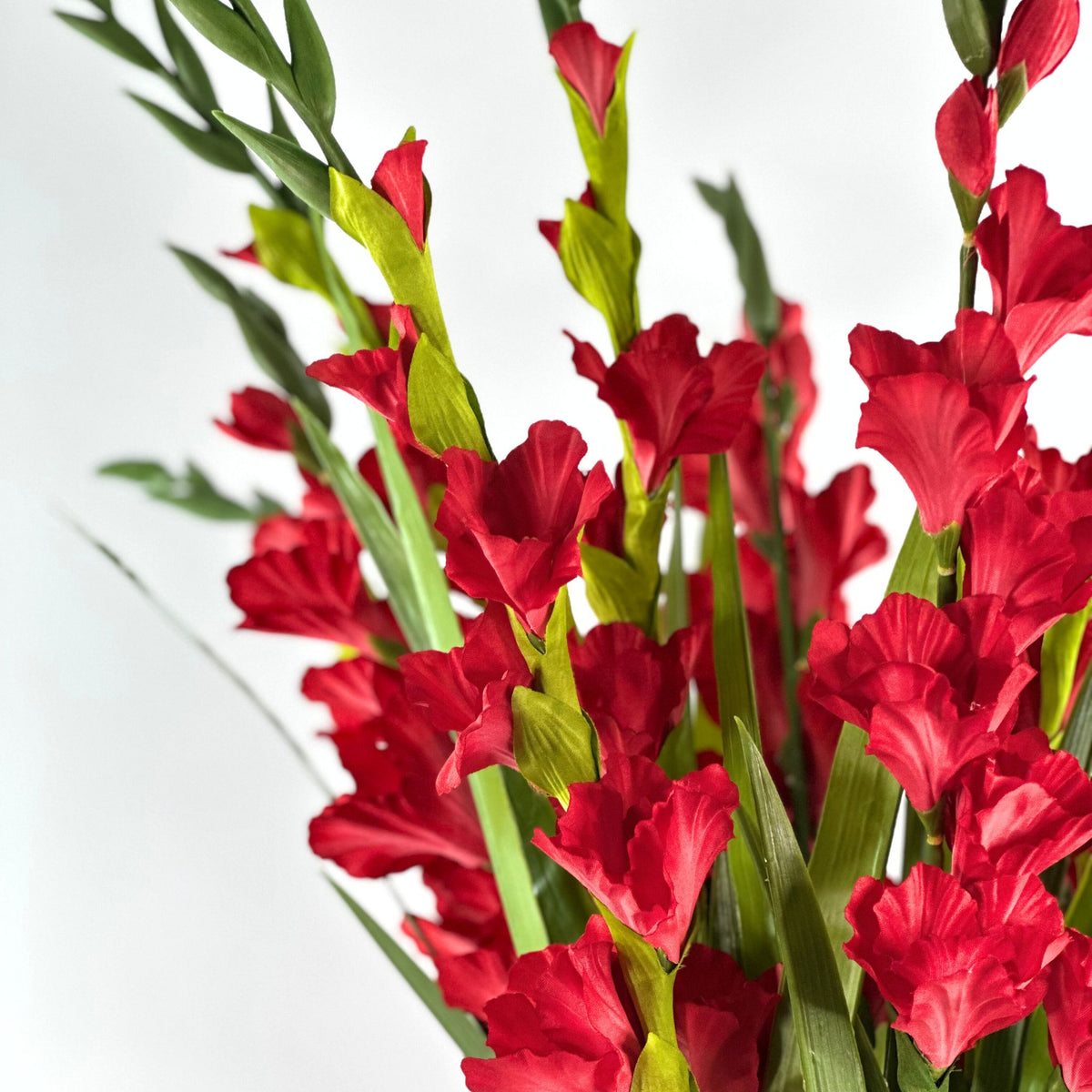 Gladioulus Red in Glass Vase. Close up view of silk flowers and stems. Available from Plant Couture.